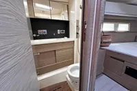 Modern bathroom and bedroom interior of 2017 Hanse 548 yacht, featuring wood accents and sleek design.