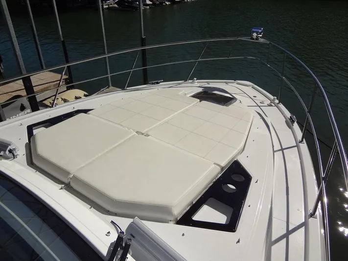  Yacht Photos Pics 2021 Cruisers Yachts 39 Express Coupe bow with sunpad, docked on calm water.