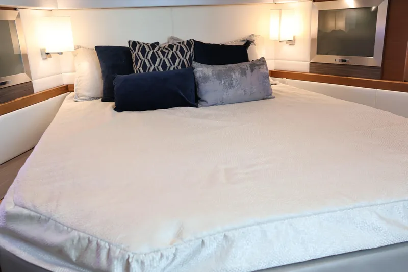 Lady Linn Yacht Photos Pics Luxurious bedroom interior of 2020 Tiara Yachts C44 Coupe with elegant bedding and cushions.