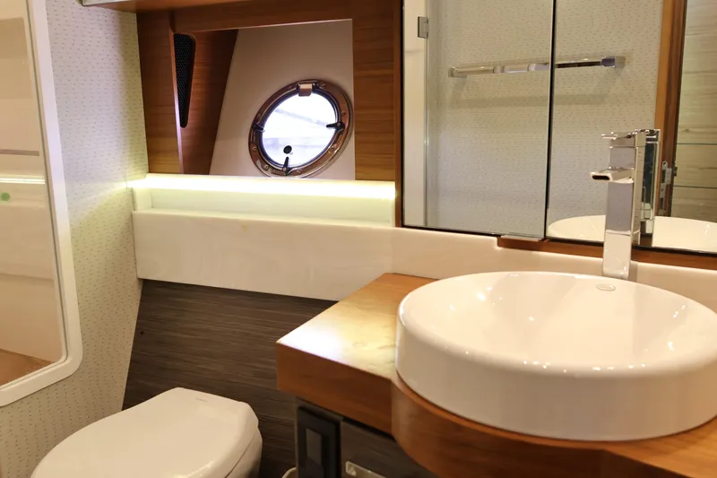 Lady Linn Yacht Photos Pics Luxurious bathroom interior of 2020 Tiara Yachts C44 Coupe with modern fixtures and porthole.
