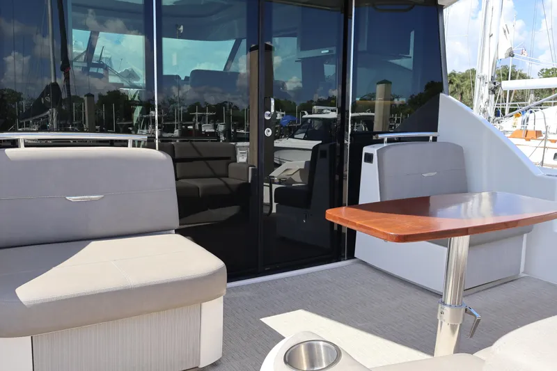 Lady Linn Yacht Photos Pics 2020 Tiara Yachts C44 Coupe cockpit with seating and wooden table, docked at marina.
