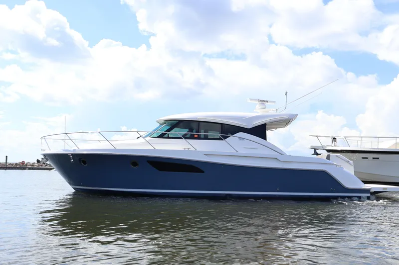 Lady Linn Yacht Photos Pics 2020 Tiara Yachts C44 Coupe cruising on calm waters under a cloudy sky.