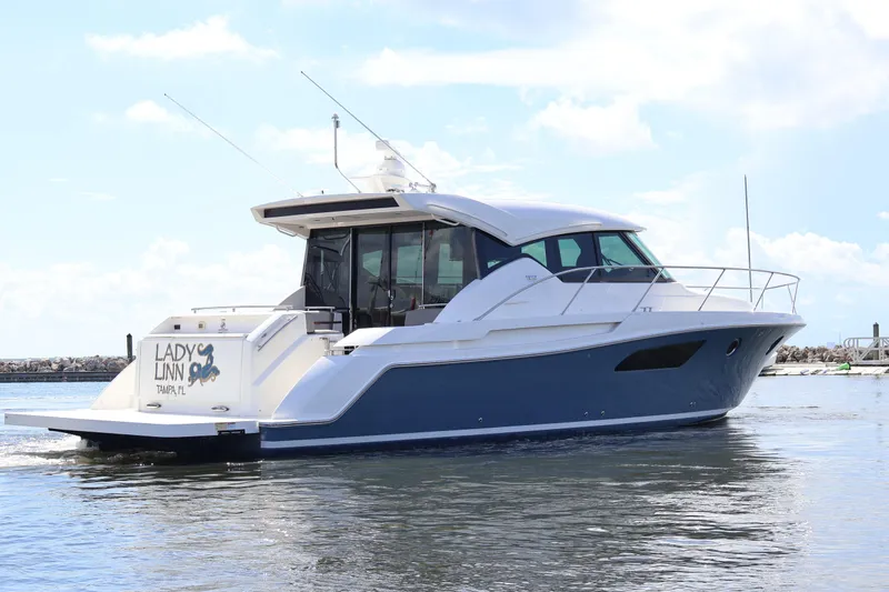 Lady Linn Yacht Photos Pics 2020 Tiara Yachts C44 Coupe cruising on water, clear sky background.