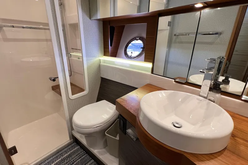 Lady Linn Yacht Photos Pics Luxurious bathroom in 2020 Tiara Yachts C44 Coupe with modern fixtures and porthole window.