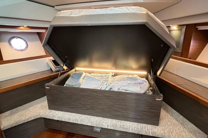 Lady Linn Yacht Photos Pics 2020 Tiara Yachts C44 Coupe interior with open storage compartment and bedding.