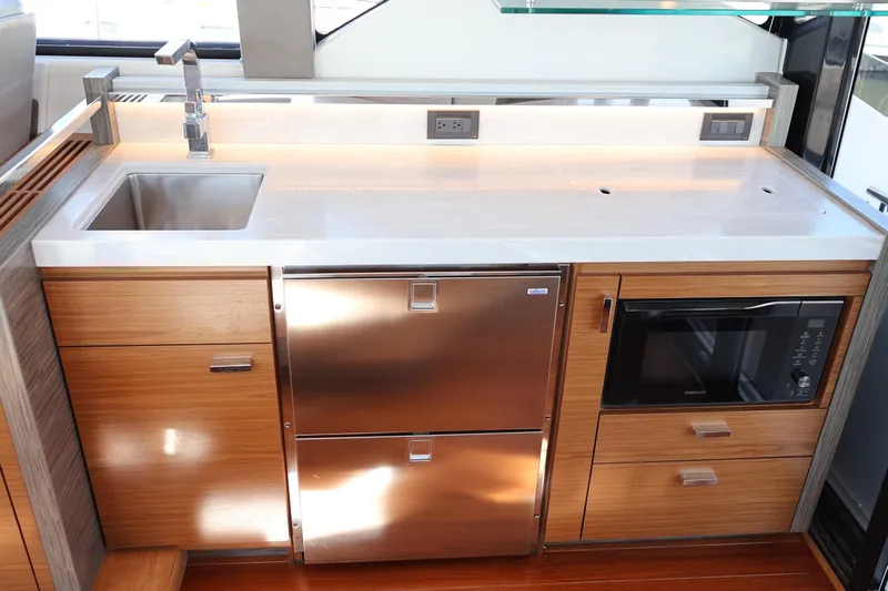 Lady Linn Yacht Photos Pics Modern kitchen in 2020 Tiara Yachts C44 Coupe with stainless steel appliances and wood cabinetry.