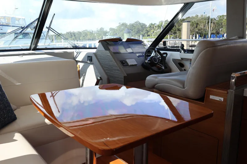 Lady Linn Yacht Photos Pics Interior of 2020 Tiara Yachts C44 Coupe, featuring helm and polished wooden table.