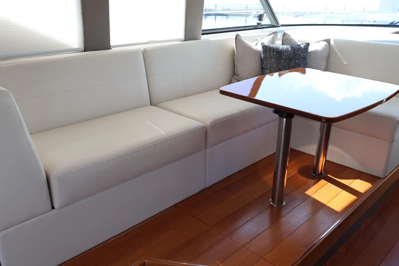 Lady Linn Yacht Photos Pics Luxurious interior of 2020 Tiara Yachts C44 Coupe with elegant seating and wooden table.