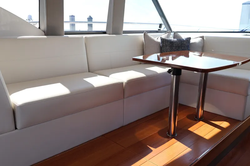 Lady Linn Yacht Photos Pics Luxurious interior of 2020 Tiara Yachts C44 Coupe with elegant seating and wooden table.