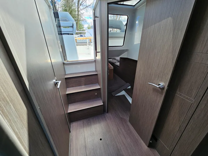  Yacht Photos Pics 2024 Beneteau Flyer 10 interior with wooden flooring and stairs leading to cabin.