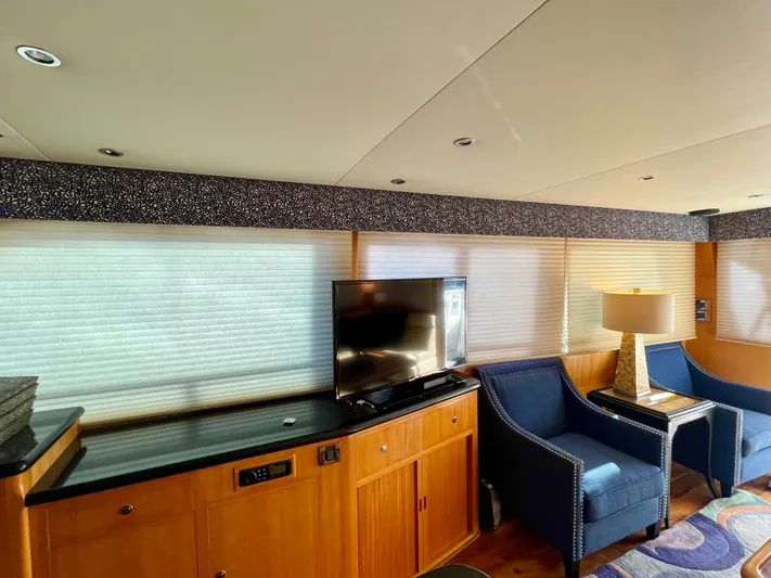 What A Life Yacht Photos Pics Interior of 2003 Ocean Alexander 510 Classico yacht with TV, blue chairs, and wooden cabinetry.