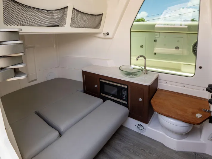  Yacht Photos Pics 2020 Solace 34 boat interior with kitchenette, seating, and compact bathroom.