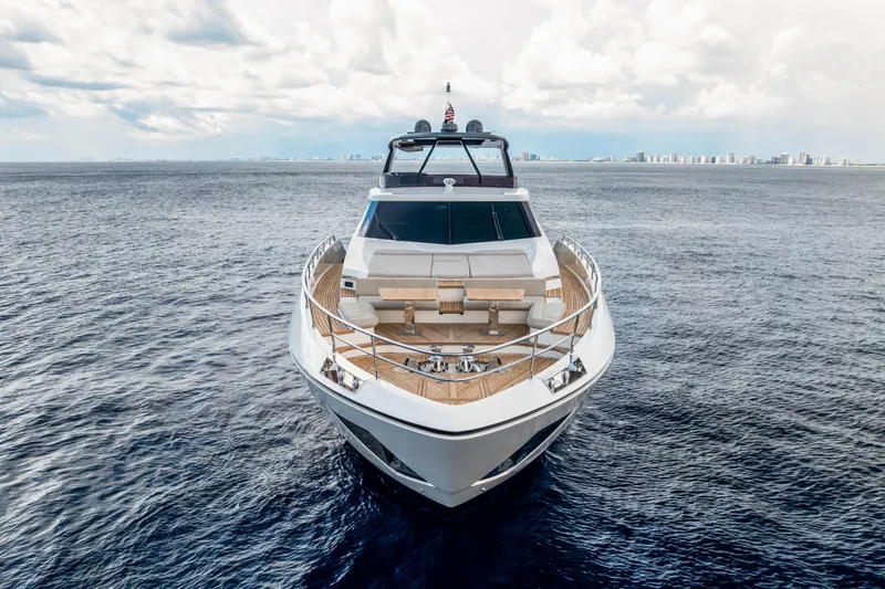 Our Trade Yacht Photos Pics Luxurious 2021 Ferretti Yachts 920 on open sea with city skyline in background.