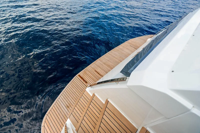 Our Trade Yacht Photos Pics Ferretti Yachts 920 (2021) with teak deck overlooking calm blue ocean waters.