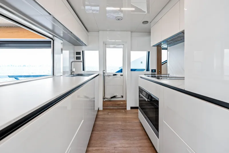 Our Trade Yacht Photos Pics Modern kitchen interior on 2021 Ferretti Yachts 920, featuring sleek white cabinetry and ocean view.