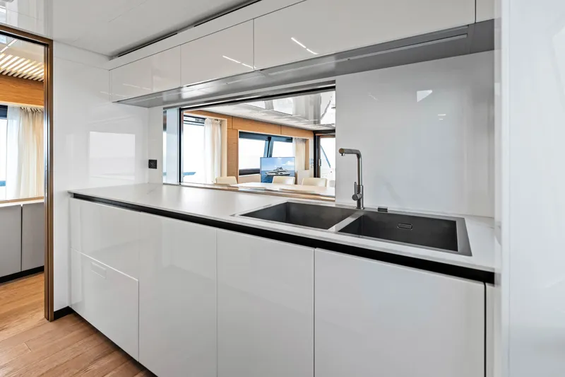 Our Trade Yacht Photos Pics Modern kitchen interior on 2021 Ferretti Yachts 920, featuring sleek cabinetry and dual sinks.