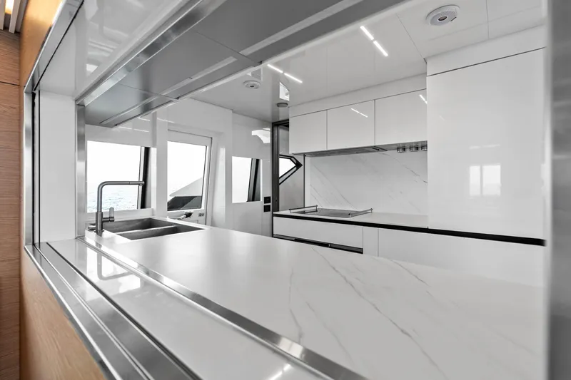 Our Trade Yacht Photos Pics Modern kitchen interior on 2021 Ferretti Yachts 920, featuring sleek white cabinetry and countertops.