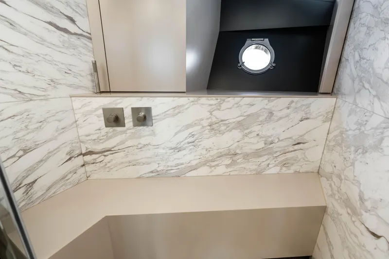 Our Trade Yacht Photos Pics Luxurious marble bathroom interior on 2021 Ferretti Yachts 920, featuring modern fixtures and porthole window.