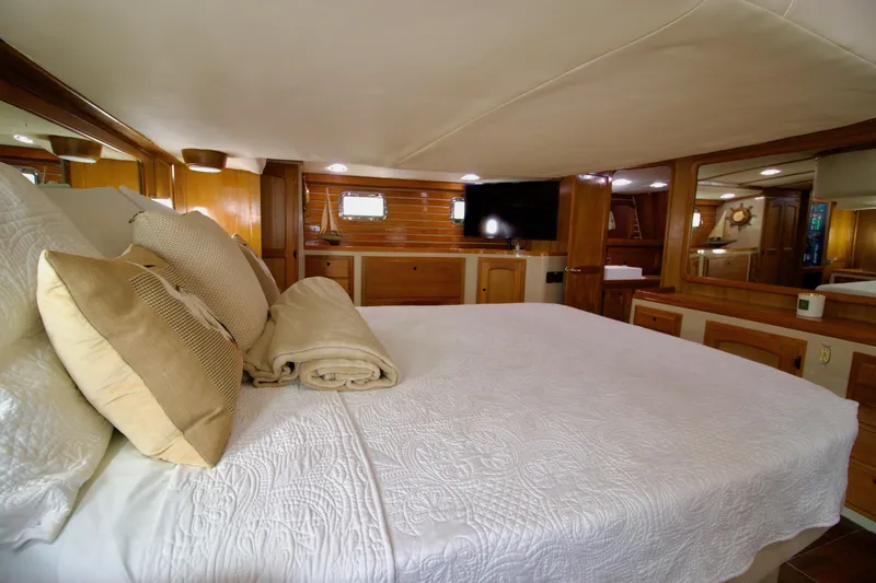 Sarita Sea Yacht Photos Pics Luxurious 1983 Lancer Yachts Motorsailer bedroom with elegant wood finish and cozy bedding.