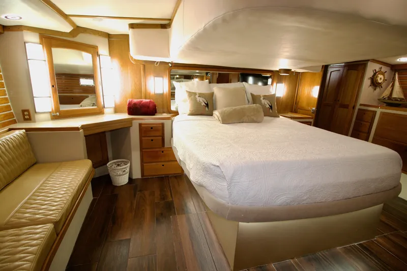 Sarita Sea Yacht Photos Pics Luxurious 1983 Lancer Yachts Motorsailer bedroom with elegant wood finishes and cozy bedding.