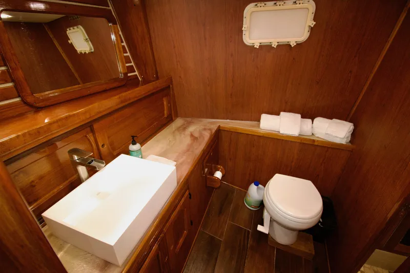 Sarita Sea Yacht Photos Pics Luxurious wooden bathroom in 1983 Lancer Yachts Motorsailer, featuring sink and toilet.
