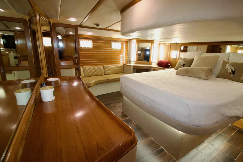 Sarita Sea Yacht Photos Pics Luxurious 1983 Lancer Yachts Motorsailer bedroom with elegant wood finishes and cozy seating area.