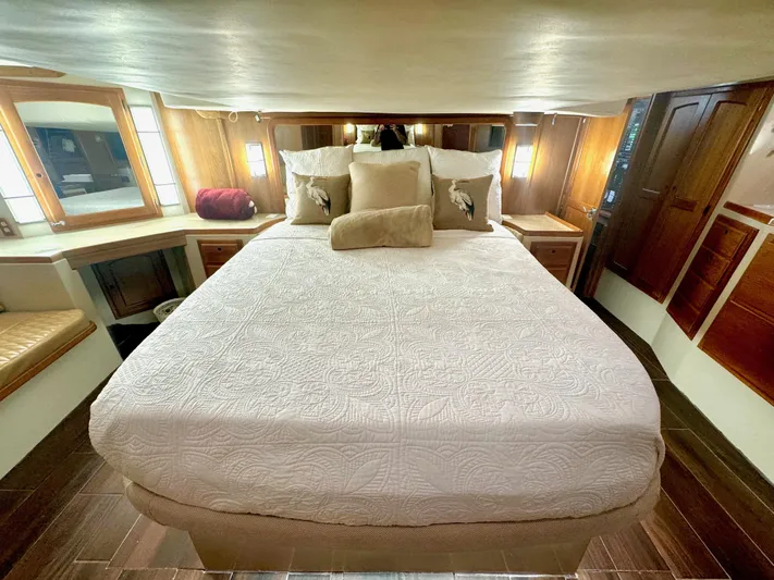 Sarita Sea Yacht Photos Pics Luxurious 1983 Lancer Yachts Motorsailer bedroom with elegant wood paneling and cozy bedding.