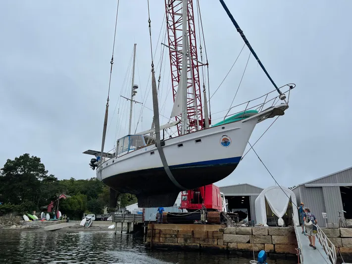 Litha Yacht Photos Pics 1988 Irwin 54 Center Cockpit sailboat being lifted by crane at a marina.