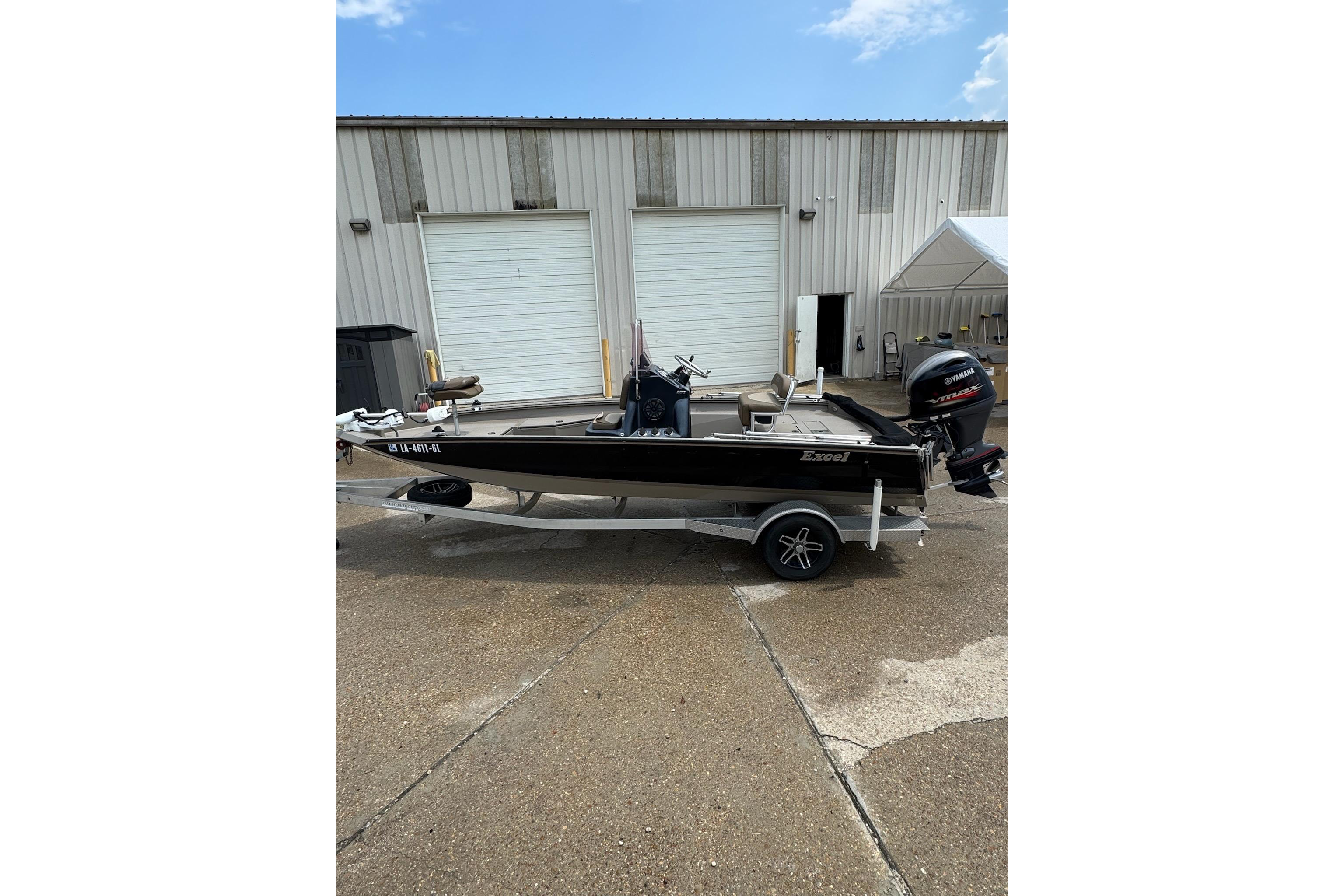 2020 Excel 203 Bay Pro boat on trailer, parked outside a garage.