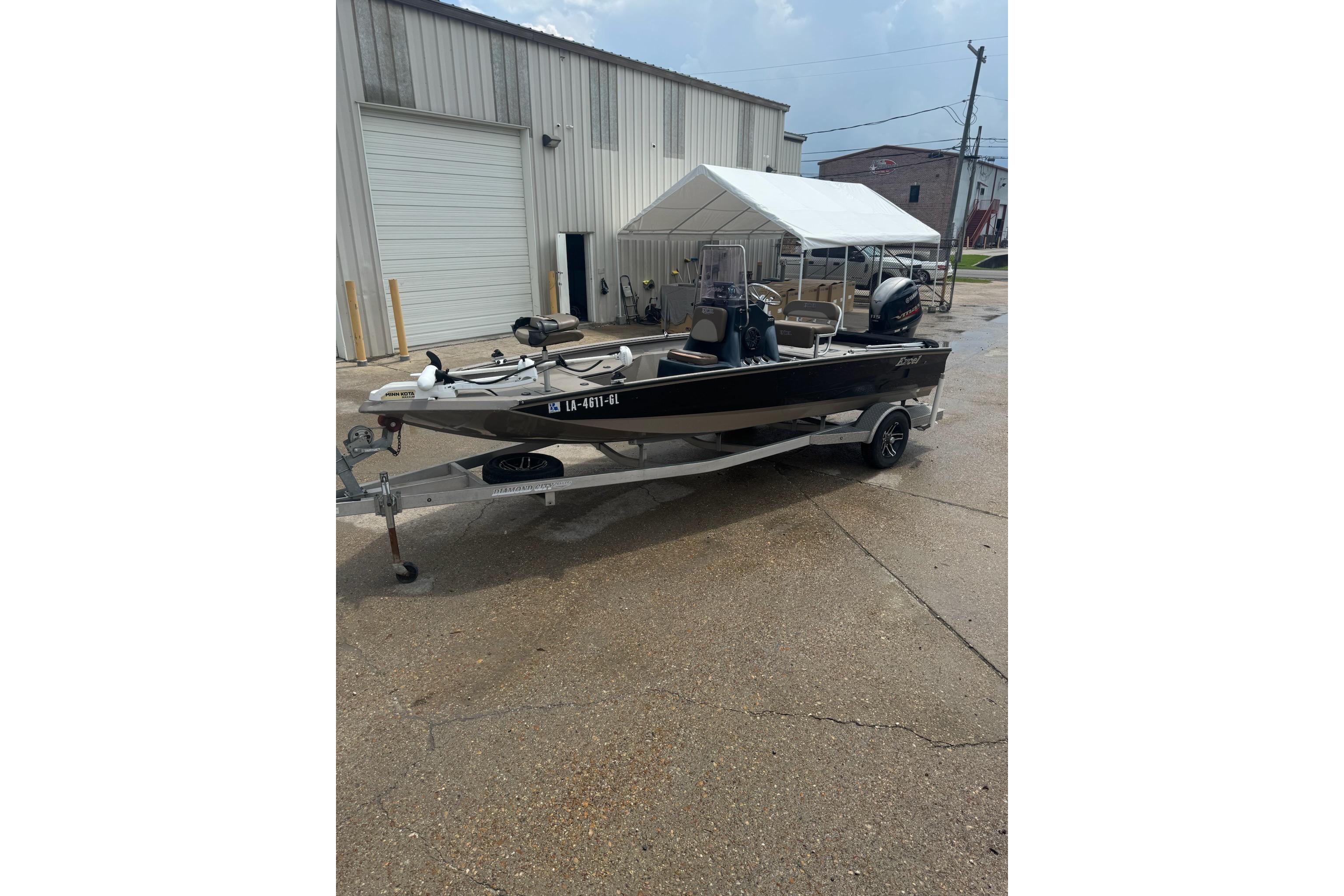 2020 Excel 203 Bay Pro boat on trailer, parked outside industrial building.