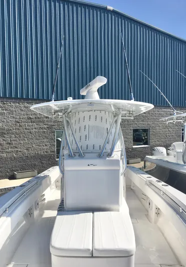  Yacht Photos Pics 2024 Contender 32 ST boat with center console, docked near a blue warehouse.