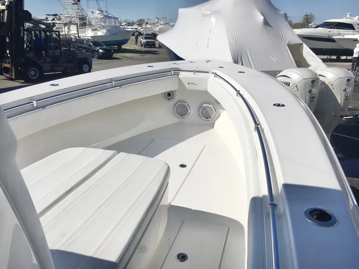 Yacht Photos Pics 2024 Contender 32 ST boat interior with seating and speakers, docked at a marina.