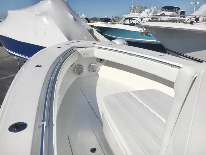  Yacht Photos Pics 2024 Contender 32 ST boat interior with white seating and sleek design in a marina setting.