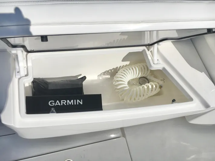 Yacht Photos Pics 2024 Contender 32 ST boat compartment with Garmin equipment and coiled hose.