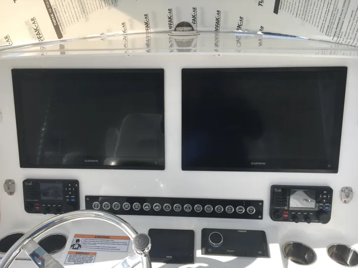  Yacht Photos Pics 2024 Contender 32 ST boat dashboard with dual Garmin screens and control panel.