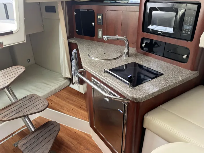  Yacht Photos Pics 2015 Robalo R305 Walkaround boat interior with kitchenette, sink, stove, and microwave.