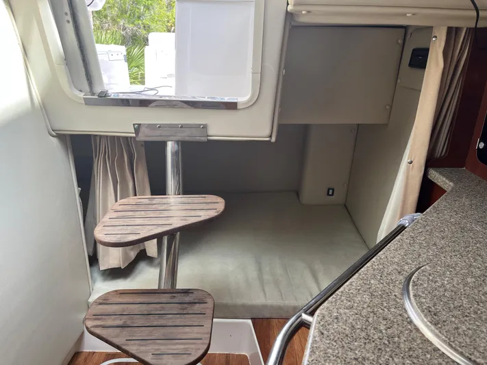  Yacht Photos Pics 2015 Robalo R305 Walkaround cabin interior with wooden steps and cushioned seating.