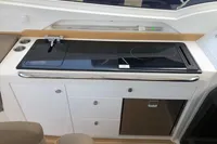 Modern kitchen area on 2023 Nimbus W9 boat with stove, sink, and storage.
