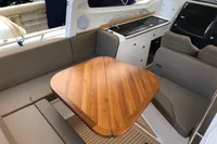 Luxurious interior of 2023 Nimbus W9 boat with wooden table and seating area.
