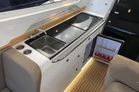 Modern kitchenette in 2023 Nimbus W9 boat with sink, stove, and mini fridge.