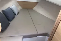 Cozy cabin interior of 2023 Nimbus W9 boat with cushions and beige upholstery.