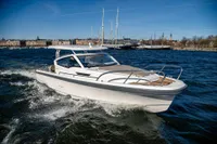 2023 Nimbus W9 boat cruising on a sunny day in a scenic harbor.