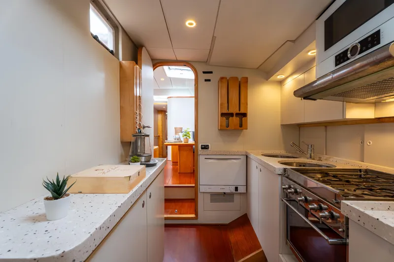 Django Too Yacht Photos Pics Luxurious kitchen interior of 1991 Trehard SLOOP 83 yacht with modern appliances and sleek design.