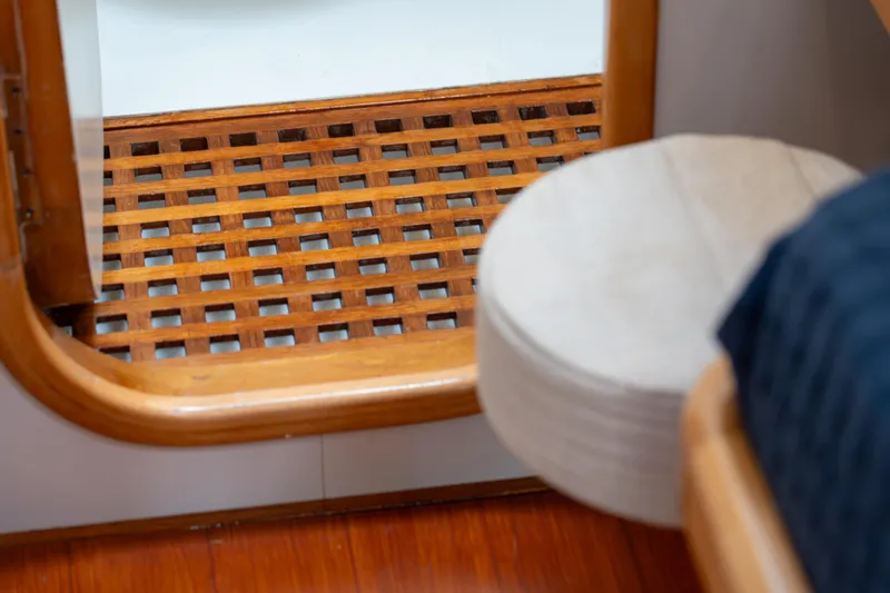 Django Too Yacht Photos Pics Interior of 1991 Trehard SLOOP 83 yacht, featuring wooden lattice flooring and cozy seating.