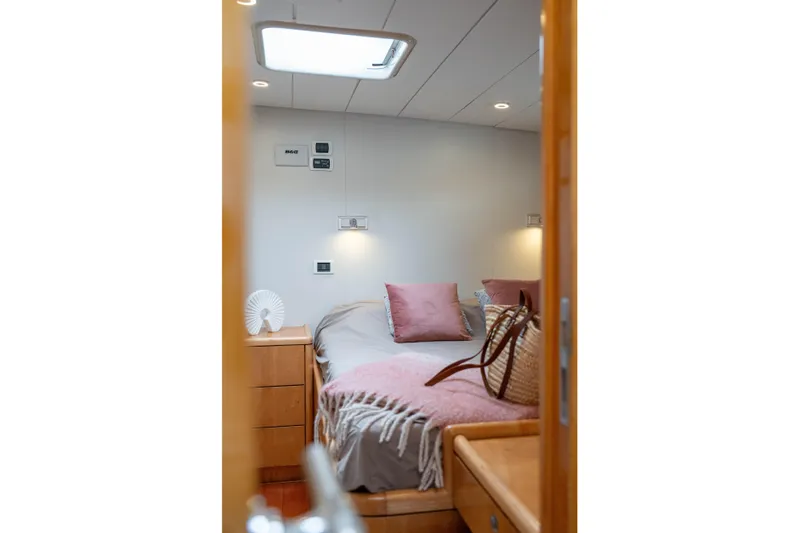 Django Too Yacht Photos Pics Cozy bedroom interior of 1991 Trehard SLOOP 83 yacht with soft lighting and decor.
