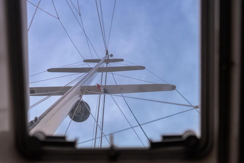 Django Too Yacht Photos Pics View of Trehard SLOOP 83 mast through hatch, 1991 sailboat, against blue sky.