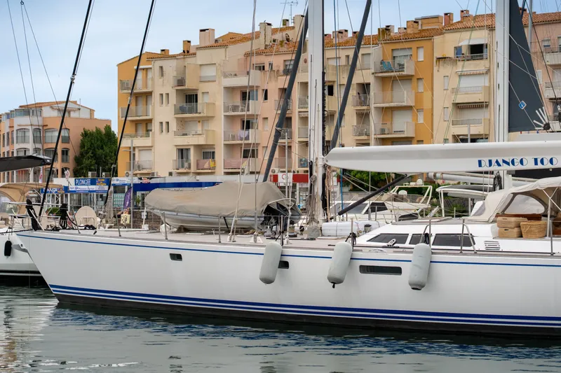 Django Too Yacht Photos Pics Trehard SLOOP 83 yacht docked in marina, 1991 model, with buildings in background.