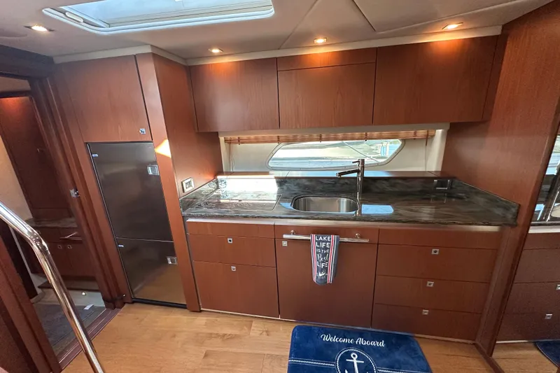 Life's Grande Yacht Photos Pics Luxurious kitchen interior of 2012 Sea Ray 470 Sundancer yacht with wood cabinetry.