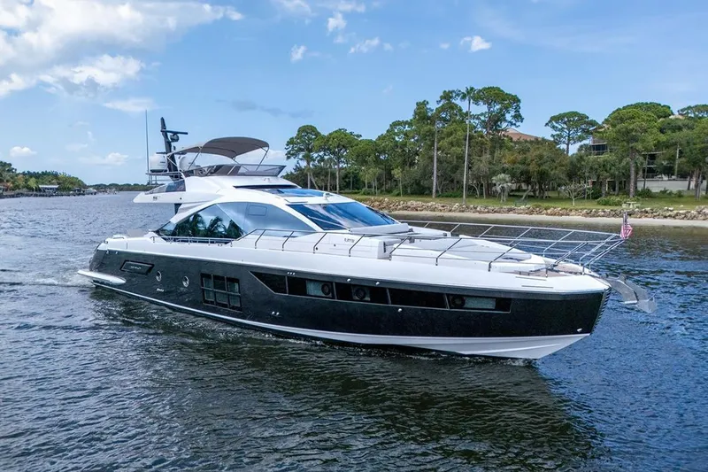 Evexias Yacht Photos Pics 2020 Azimut S7 FLY yacht cruising on a scenic waterway with lush greenery.