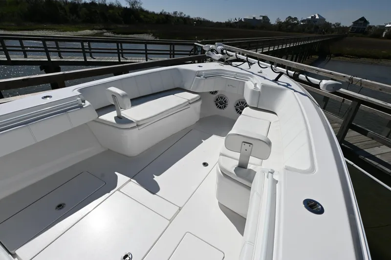  Yacht Photos Pics 2023 Contender 32ST boat interior with seating, docked by a wooden pier.